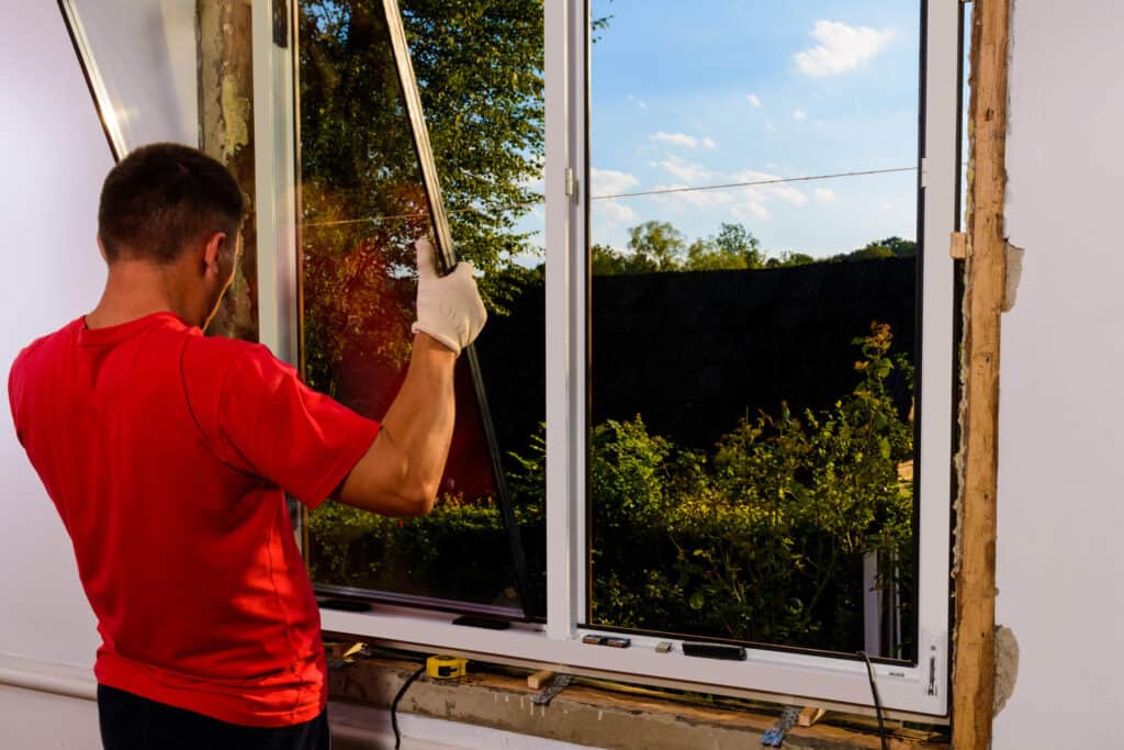 A man installing a new window