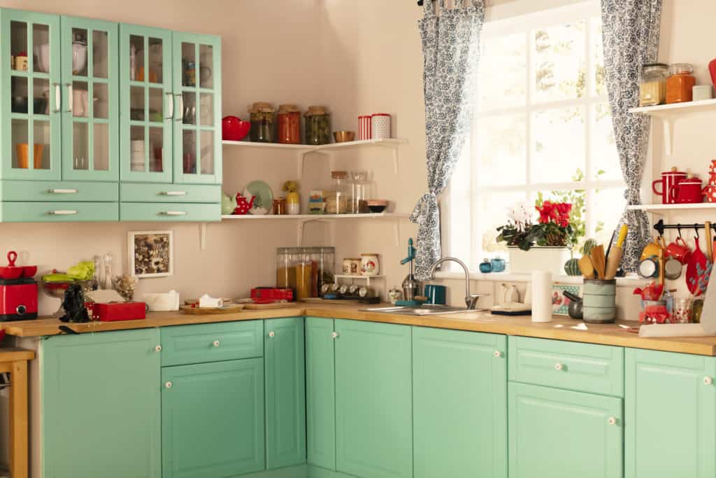 Retro kitchen with green cabinets and light pink colored walls
